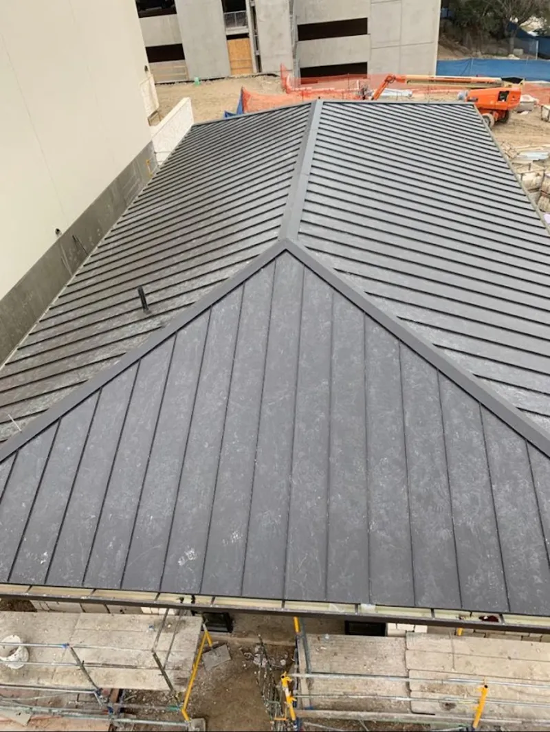 Commercial metal roof construction with crane equipment in Bismarck